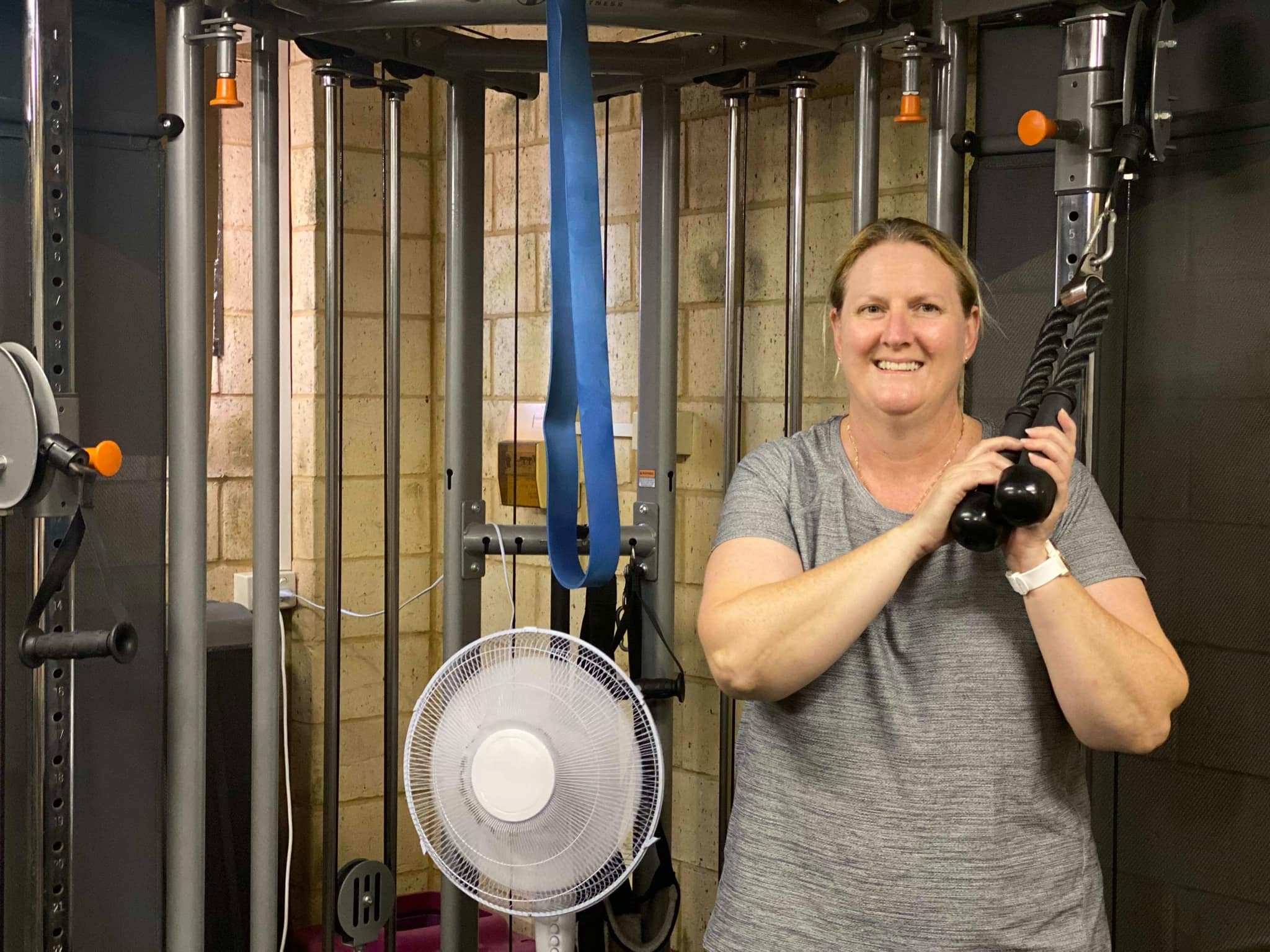 A client training on the cable machine at Hell's Bells Fitness